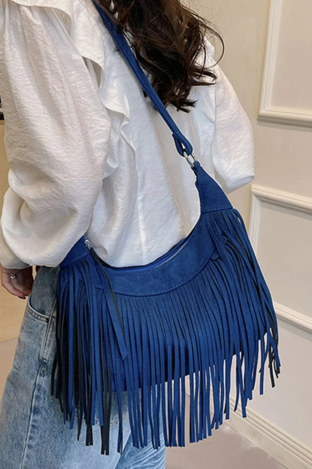 Bohemian suede crescent crossbody bag with fringe detail in navy.