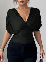 Black ruched surplice dolman sleeve top with a deep V-neckline.
