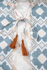 Geometric print blouse with tassel tie detail and ruffled collar.
