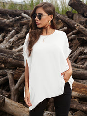 White asymmetrical sleeve blouse with draped hem, styled with black pants and jewelry.