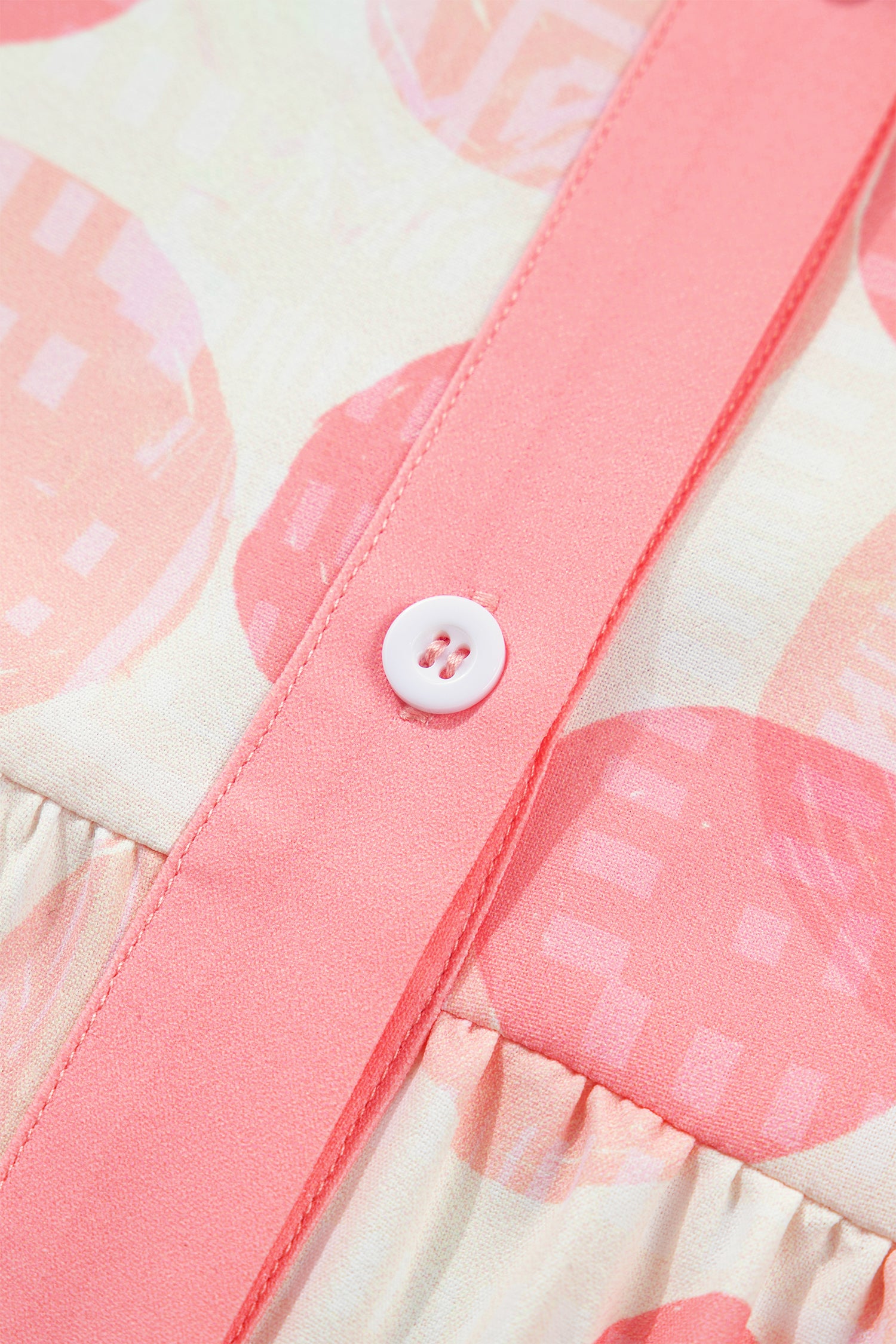 Polka dot babydoll shirt with pink ruffle trim and button detail.