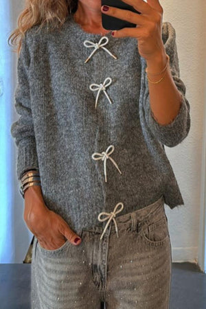 Gray knit sweater with lace-up detail and round neckline.
