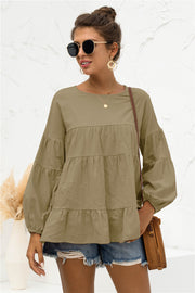 Army green tiered peasant blouse with long balloon sleeves and round neckline.