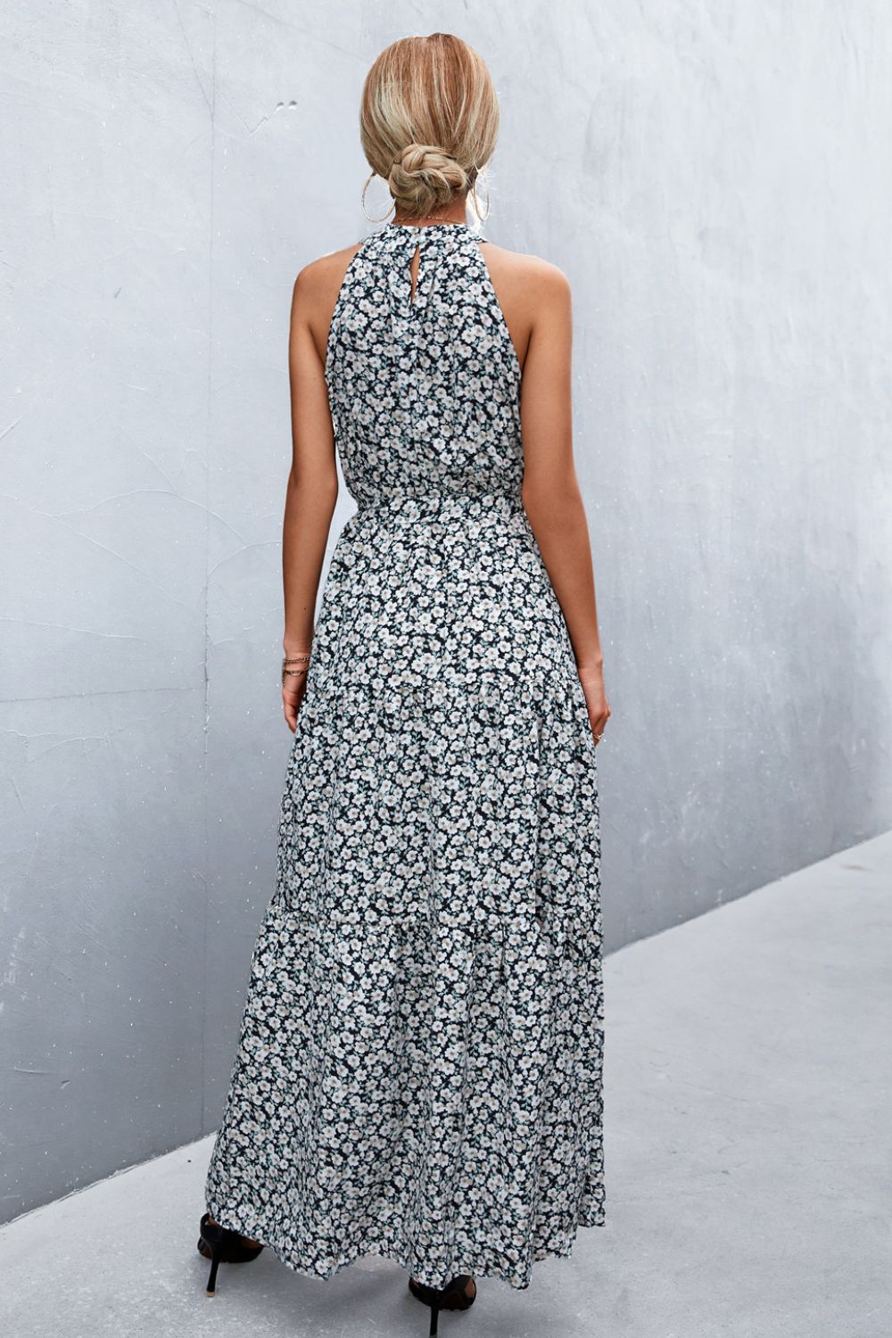 Black floral print maxi dress with halter neckline and tiered skirt.