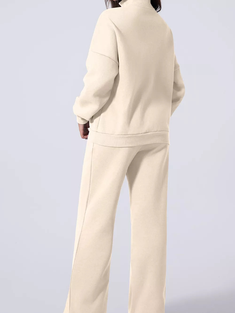 Beige cotton joggers and zip-up jacket set with drawstring pants and mock neck.