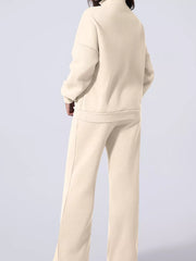 Beige cotton joggers and zip-up jacket set with drawstring pants and mock neck.