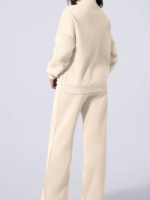 Beige cotton joggers and zip-up jacket set with drawstring pants and mock neck.