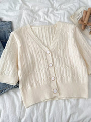 Chic cable-knit cropped cardigan in apricot with button front and V-neck.