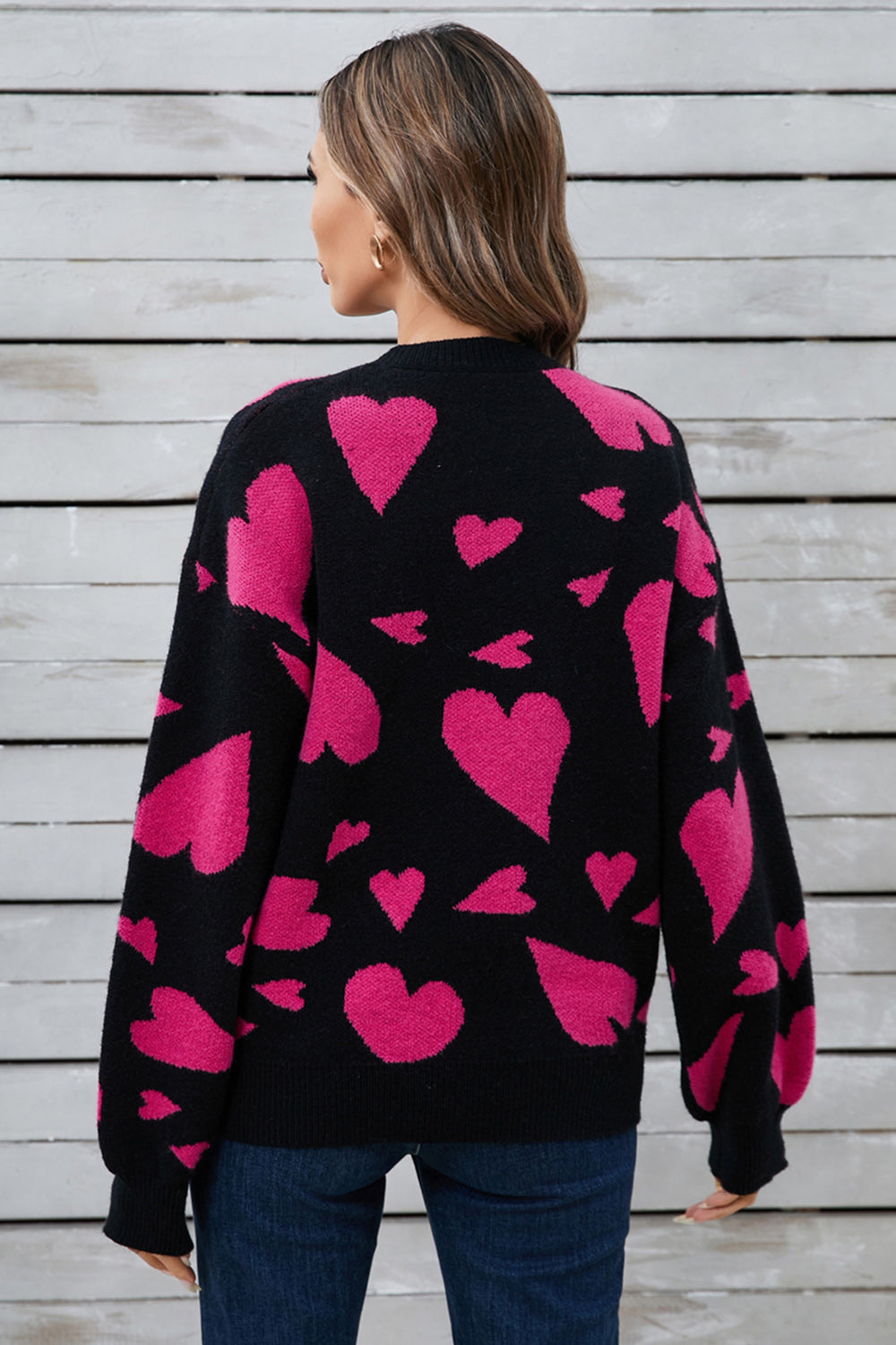 Black intarsia knit jumper with allover pink hearts pattern, crew neck, long sleeves.