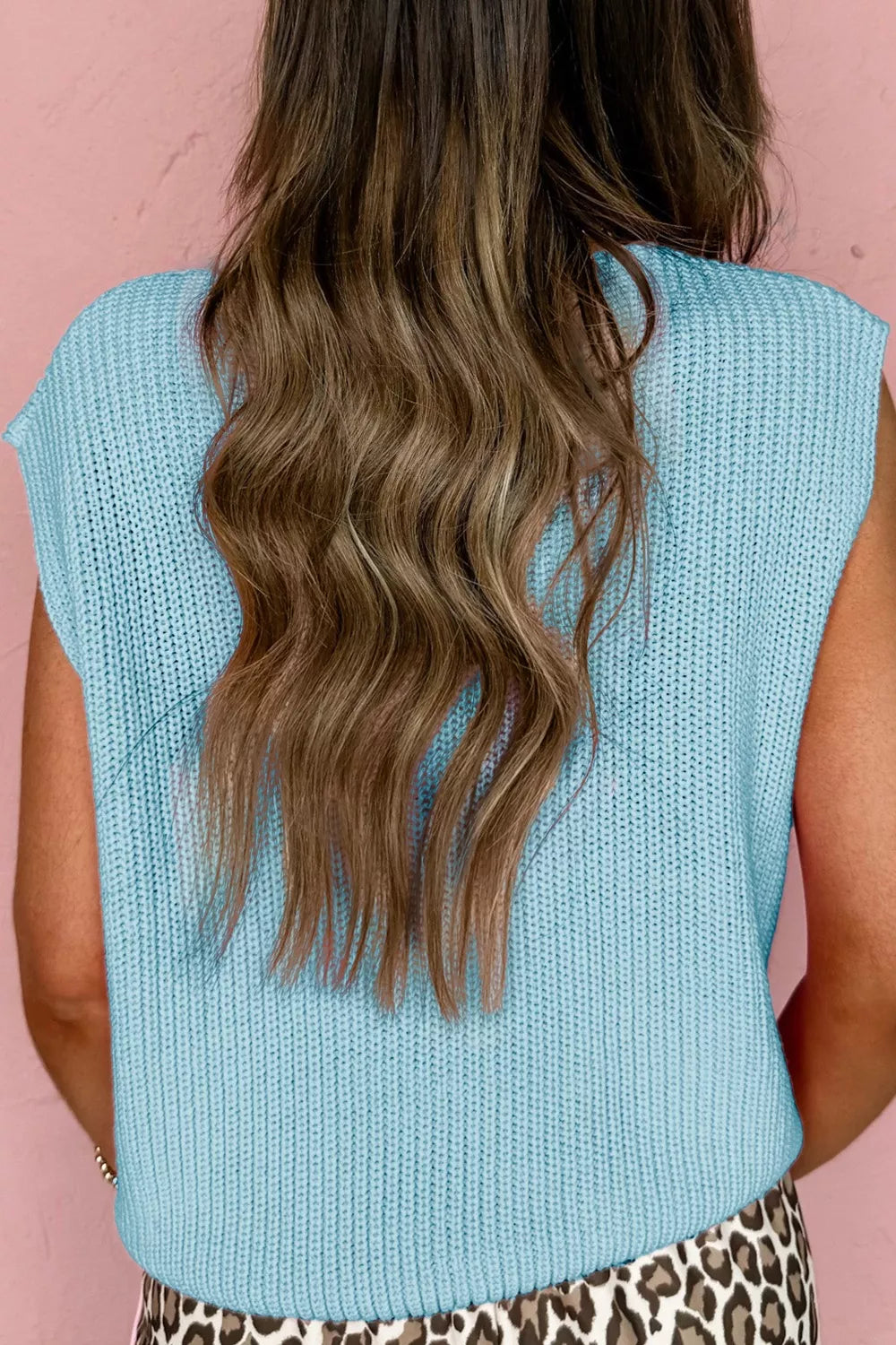 Light blue knit sweater vest with V-neck and button-down front, styled casually.