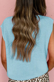 Light blue knit sweater vest with V-neck and button-down front, styled casually.