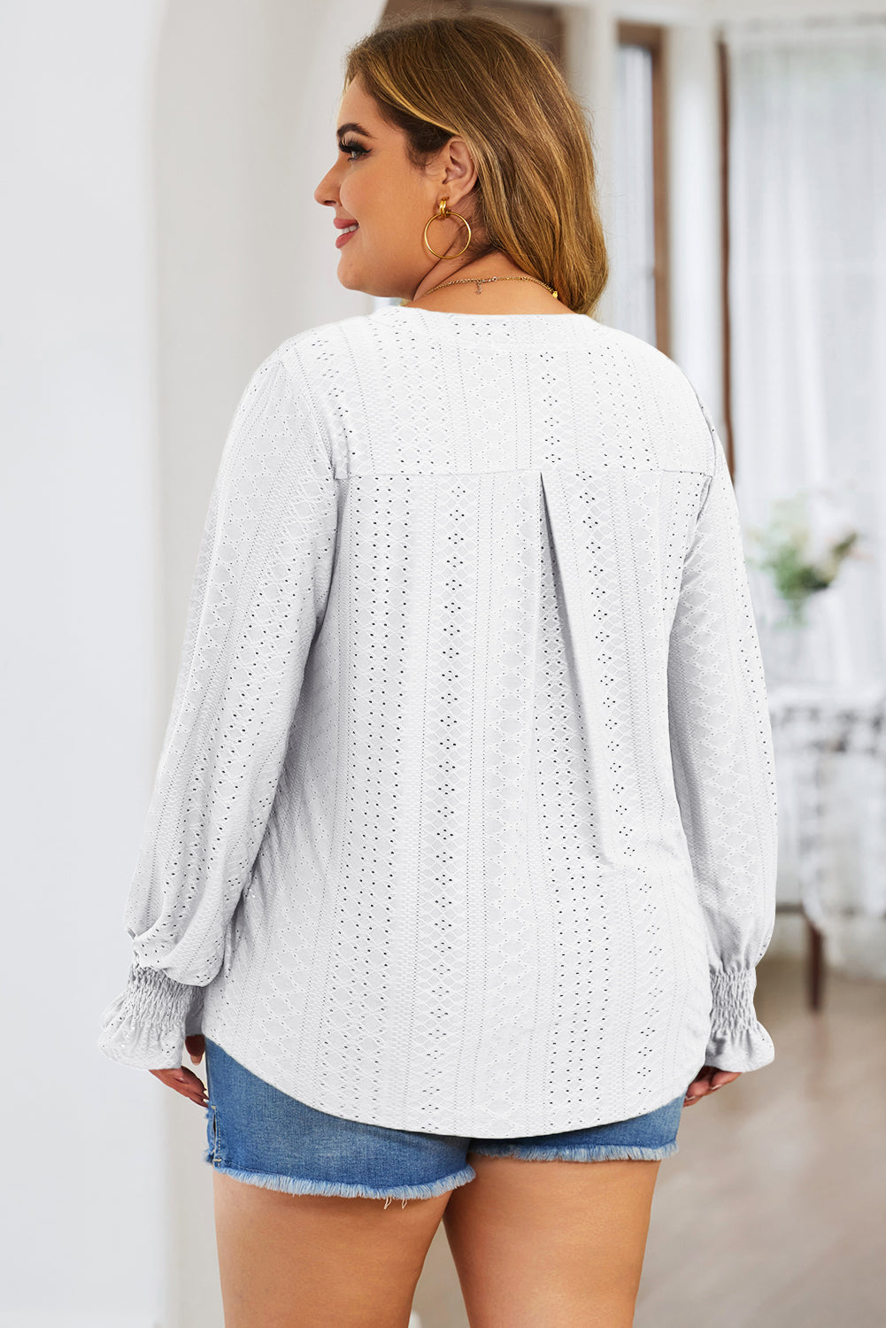 White textured blouse with shirred cuffs and a slit neckline.