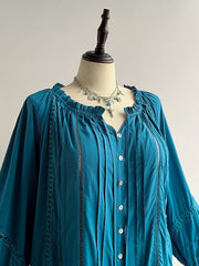 Teal ruffled lantern sleeve pleated blouse with button-down front and cutout details.