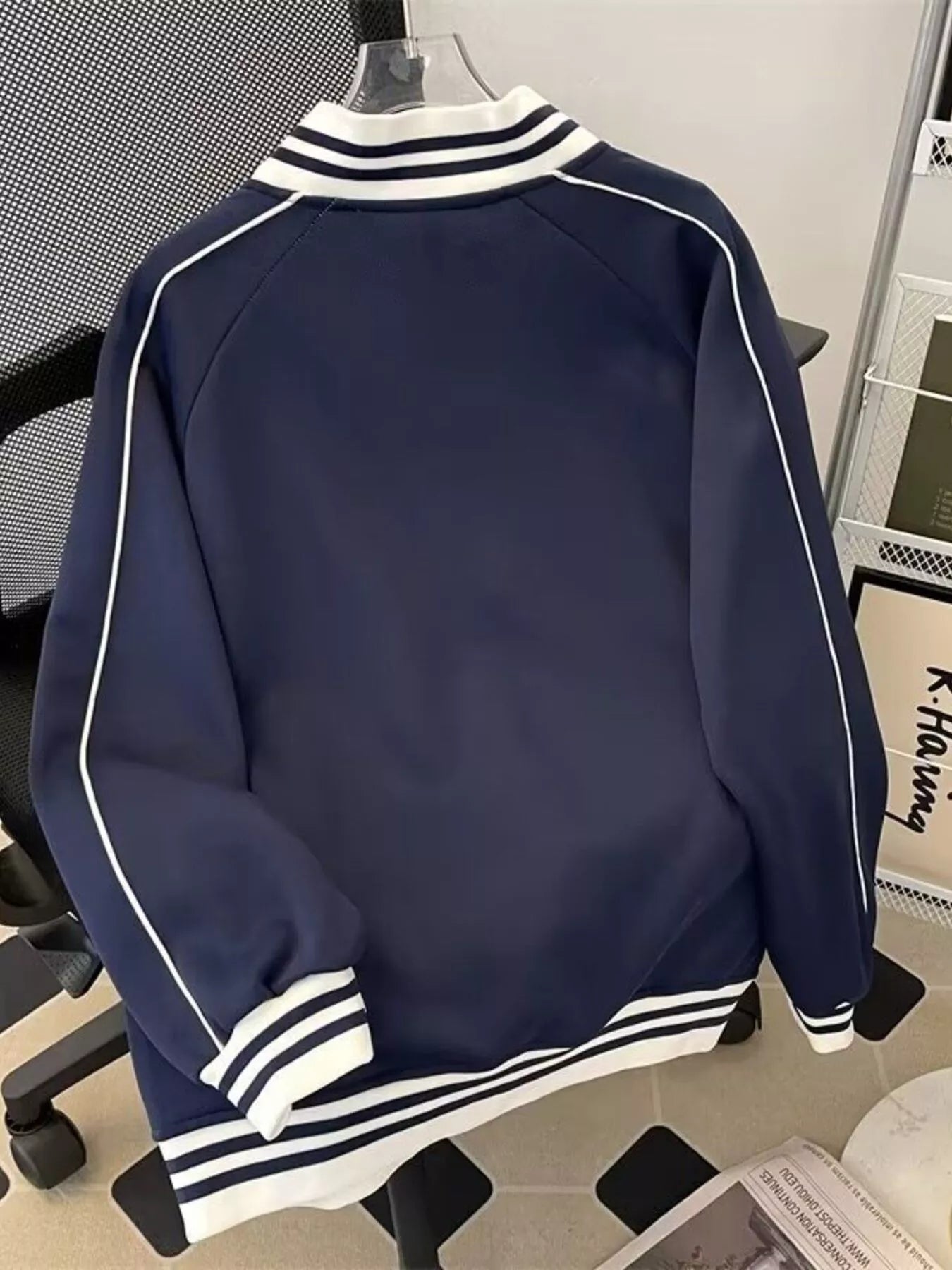 Navy blue zip-up sweatshirt with white piping and striped cuffs and collar.
