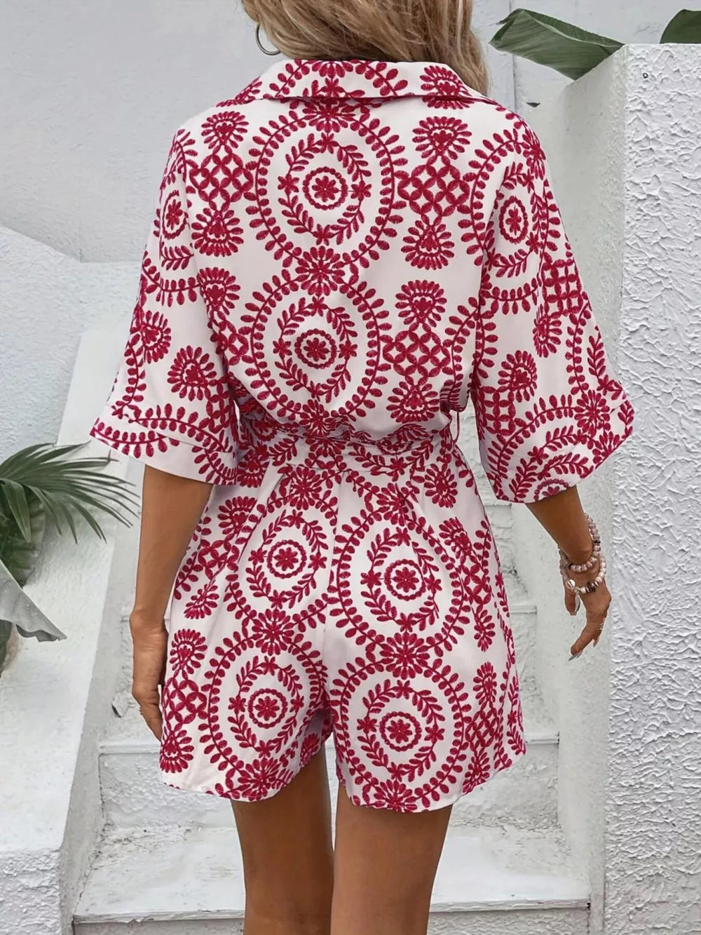 Deep Red printed tie-waist romper with buttoned collar and short sleeves.