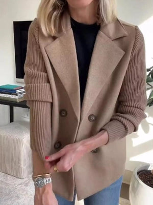 Tan double-breasted trench coat with knit sleeves and notched lapels.