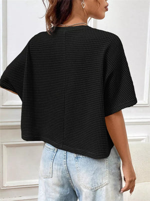 Black waffle-knit cropped t-shirt with crew neck and short sleeves.