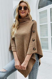 Caramel knit poncho with turtleneck and button details on sleeves.