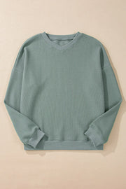 Relaxed sage waffle knit crewneck sweater with long sleeves and ribbed cuffs and hem.