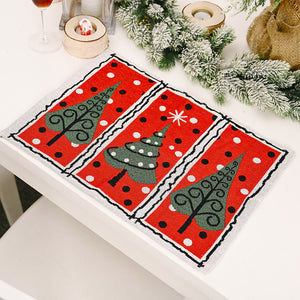 Embroidered Christmas placemats in red with green trees and white polka dots.