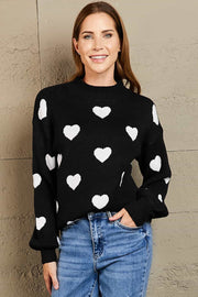 Black sweater with white hearts, mock neck, and balloon sleeves.