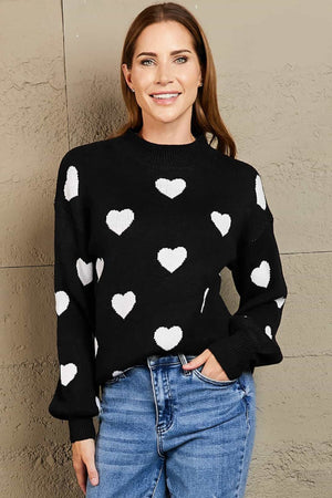 Black sweater with white hearts, mock neck, and balloon sleeves.