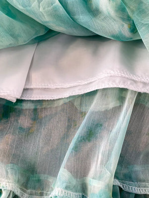 Light green floral ruffle bikini bottoms with white lining and bow detail.