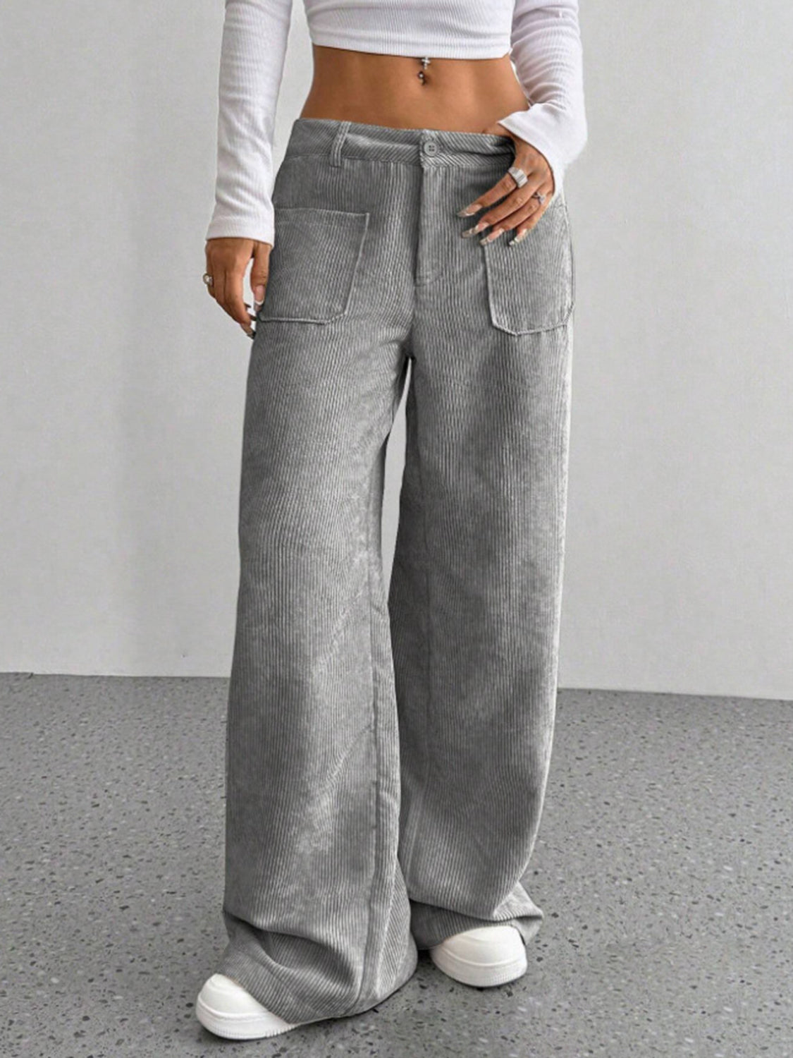 Gray corduroy wide-leg utility trousers with large front pockets and a relaxed fit.