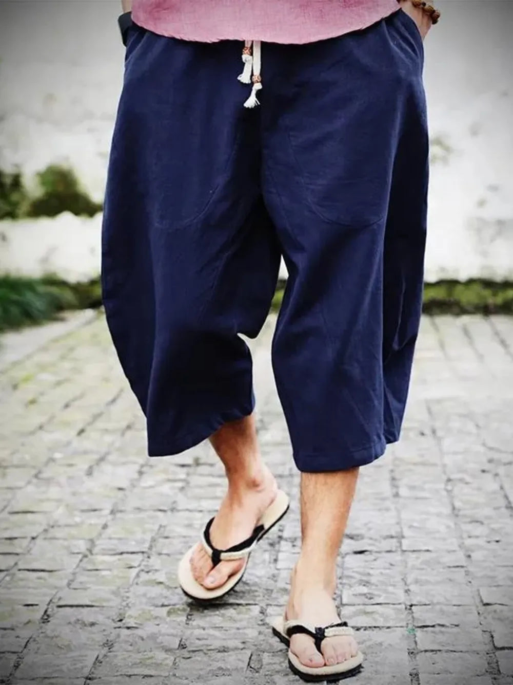Navy blue relaxed fit cropped sweatpants with drawstring waist and pockets.