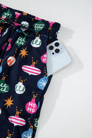 Navy blue lounge pants with festive bauble print and a phone in the pocket.