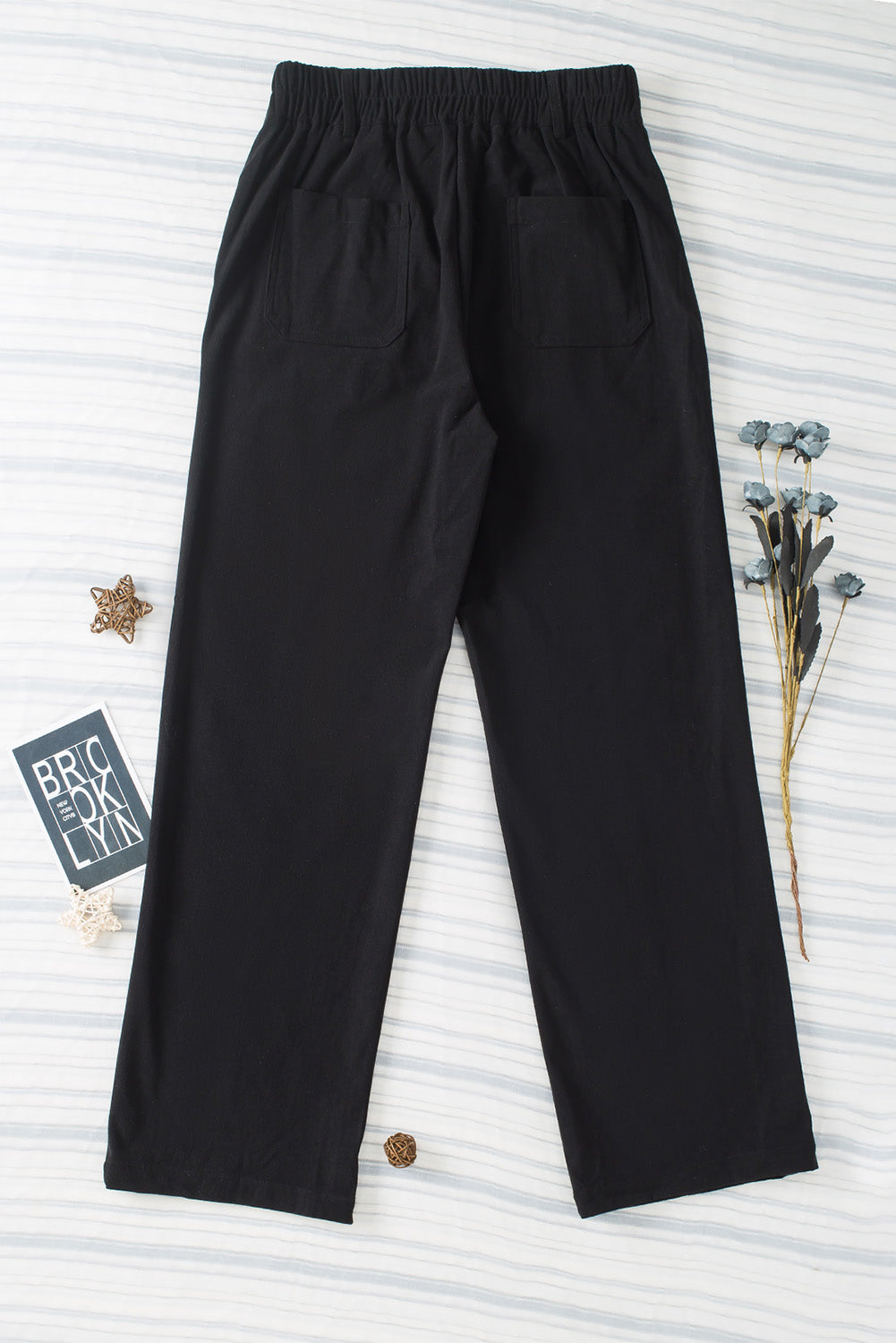 Black seamed front wide leg trousers with elastic waistband and back pockets.