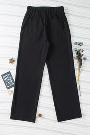 Black seamed front wide leg trousers with elastic waistband and back pockets.