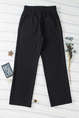 Black seamed front wide leg trousers with elastic waistband and back pockets.