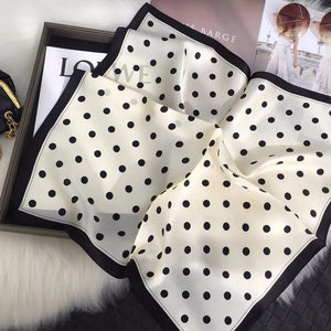 Cream white silk scarf with black polka dots and a black border.