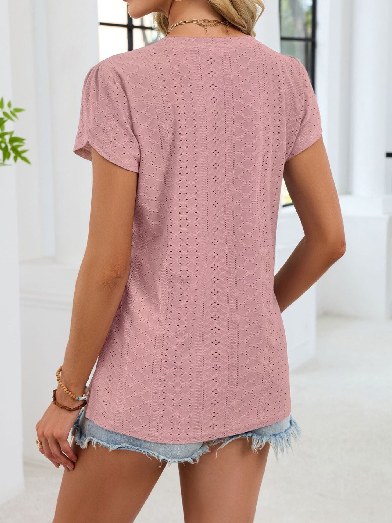 Blush pink eyelet tee with petal sleeves and V-neck, casual women's top.