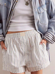 White boxer shorts with navy pinstripes, elastic waistband, and side pockets.