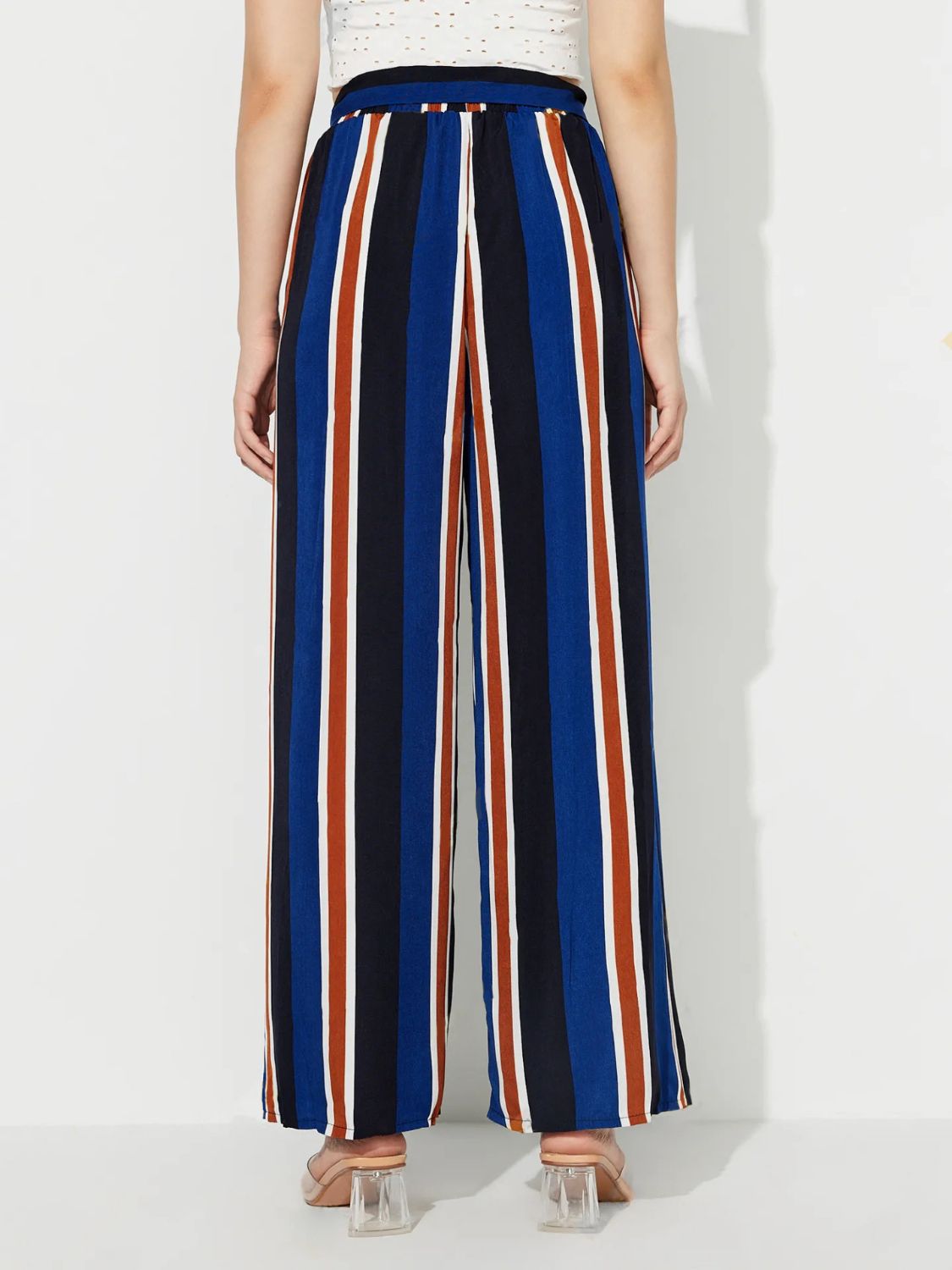 Striped palazzo trousers with side slits in blue, black, white, and rust.