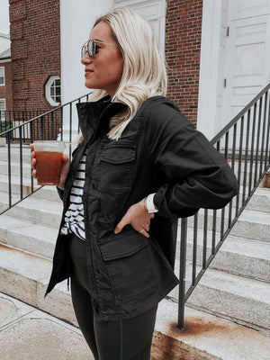 Black utility field jacket with multiple pockets and a stand-up collar.