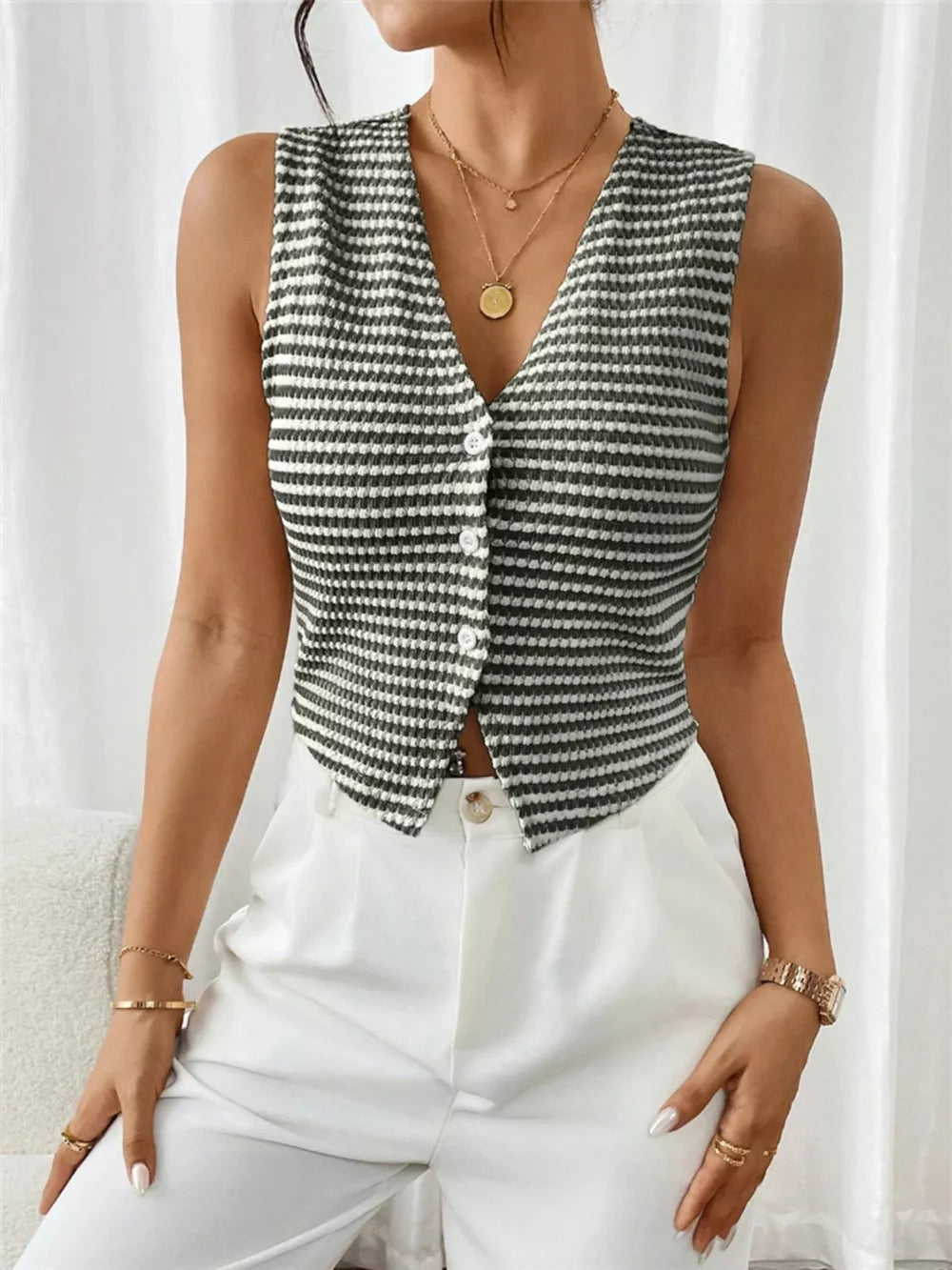 Chic striped knit v-neck tank top with button front, styled with white pants.