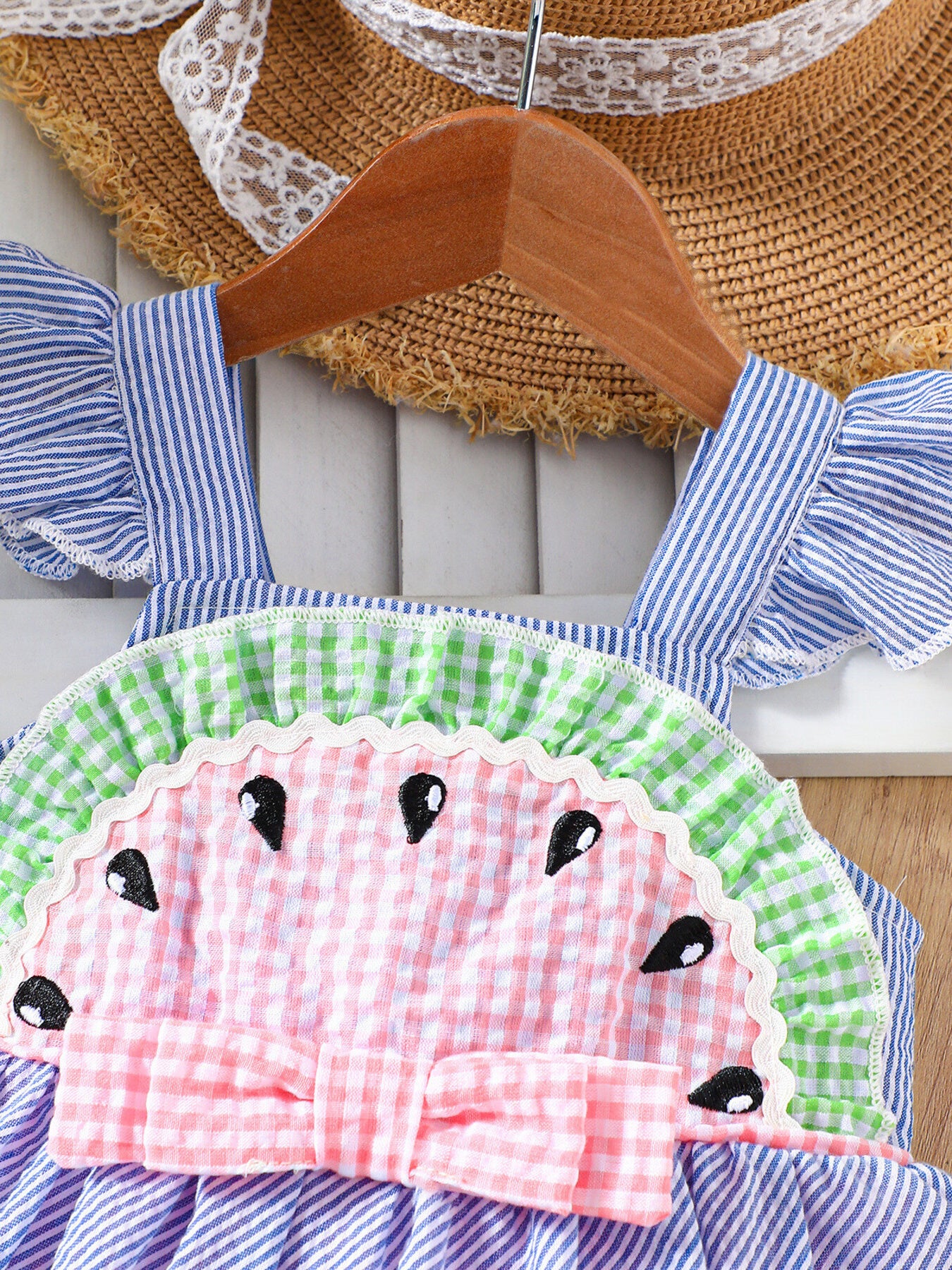 Baby dress with watermelon applique, ruffle sleeves, and bow detail.