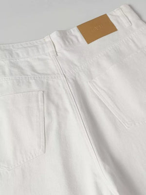 White relaxed fit sweatpants with wide legs and a tan leather logo patch.