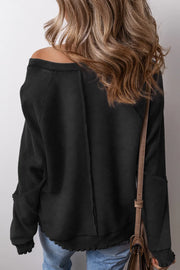Black waffle knit raglan seam sweatshirt with contrast sleeves and raw hem detail.