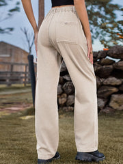Tan cargo denim trousers with elastic waistline and buttoned back pocket.