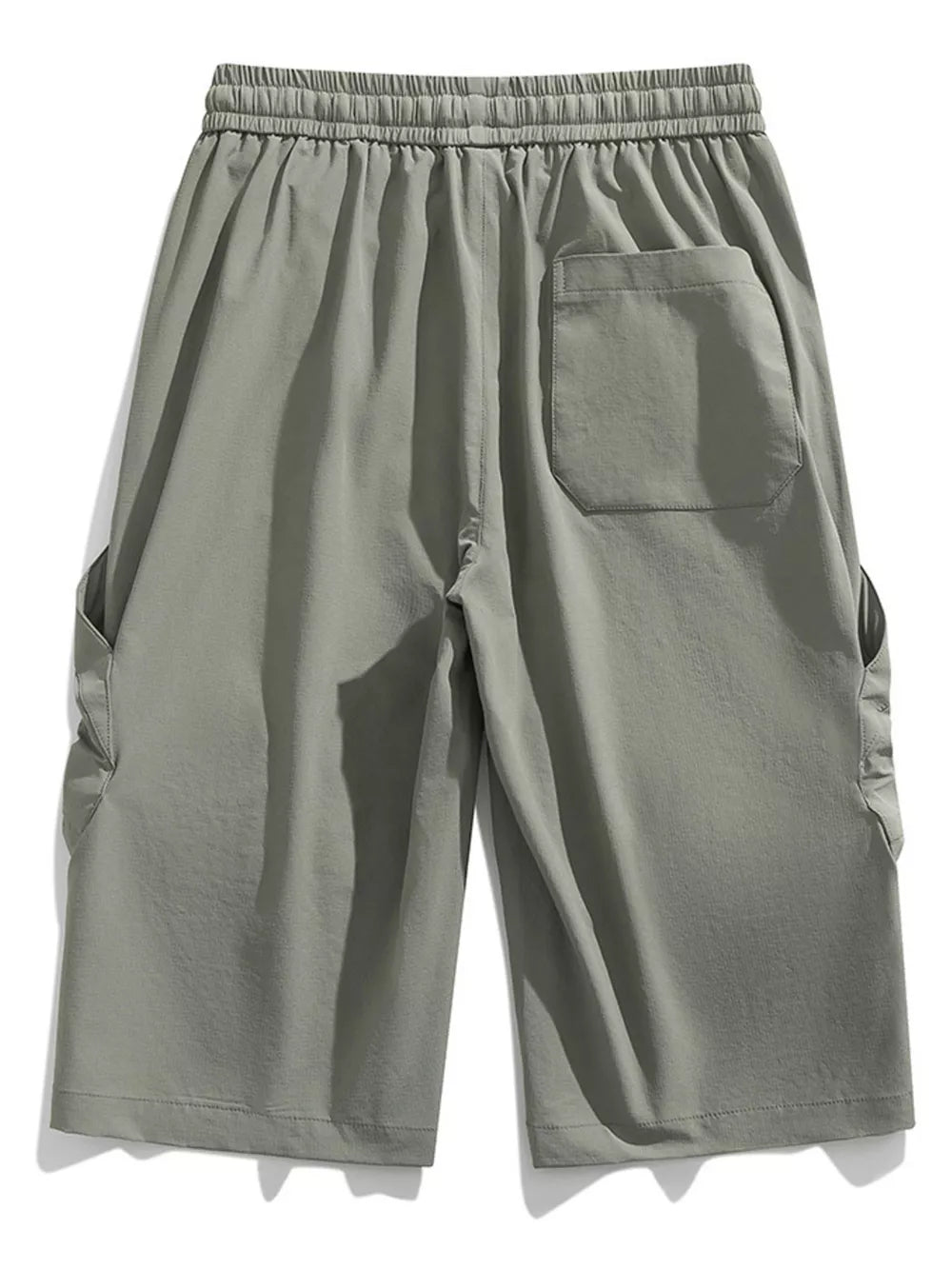 Light gray cargo capris with elastic waistband and drawstring, featuring side pockets and a back pocket.