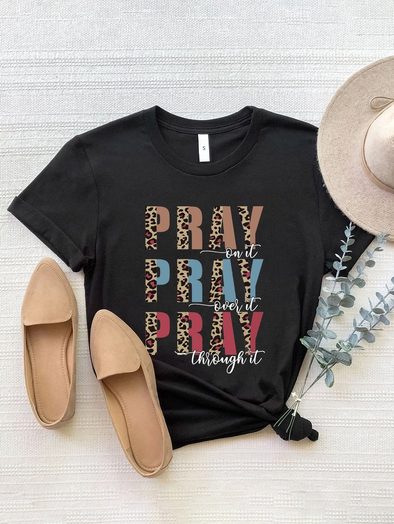 Black graphic t-shirt with leopard print and text detail.