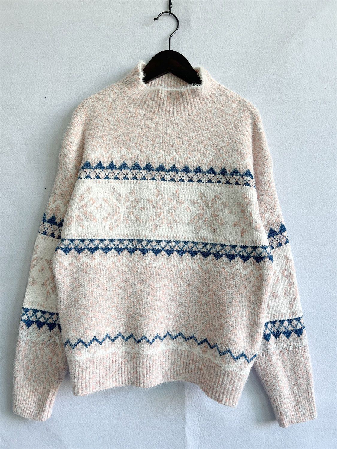 Geometric knit mockneck pullover in pastel yellow with navy and white pattern.