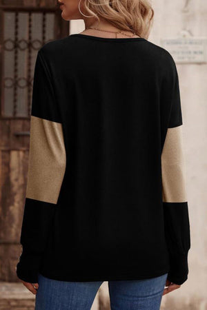 Black knit top with camel color block sleeves and button cuffs.