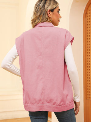 Pink utility denim vest with collar and buttoned front, worn over a white long-sleeve shirt.