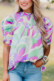 Multicolor smocked puff sleeve blouse with psychedelic print and gathered cuffs.