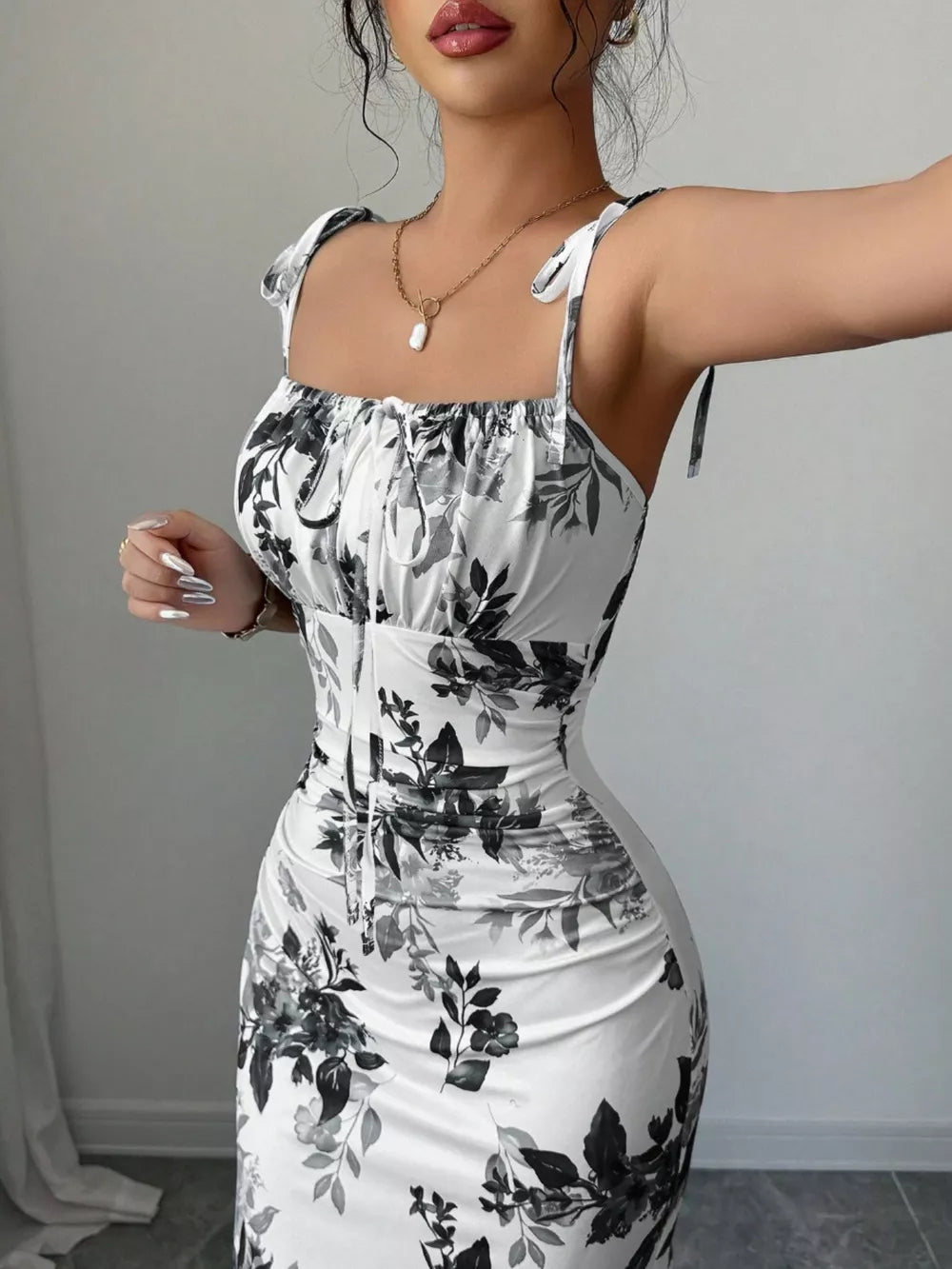 Floral print tie strap maxi dress in white with black floral pattern, square neckline, and ruched detail.